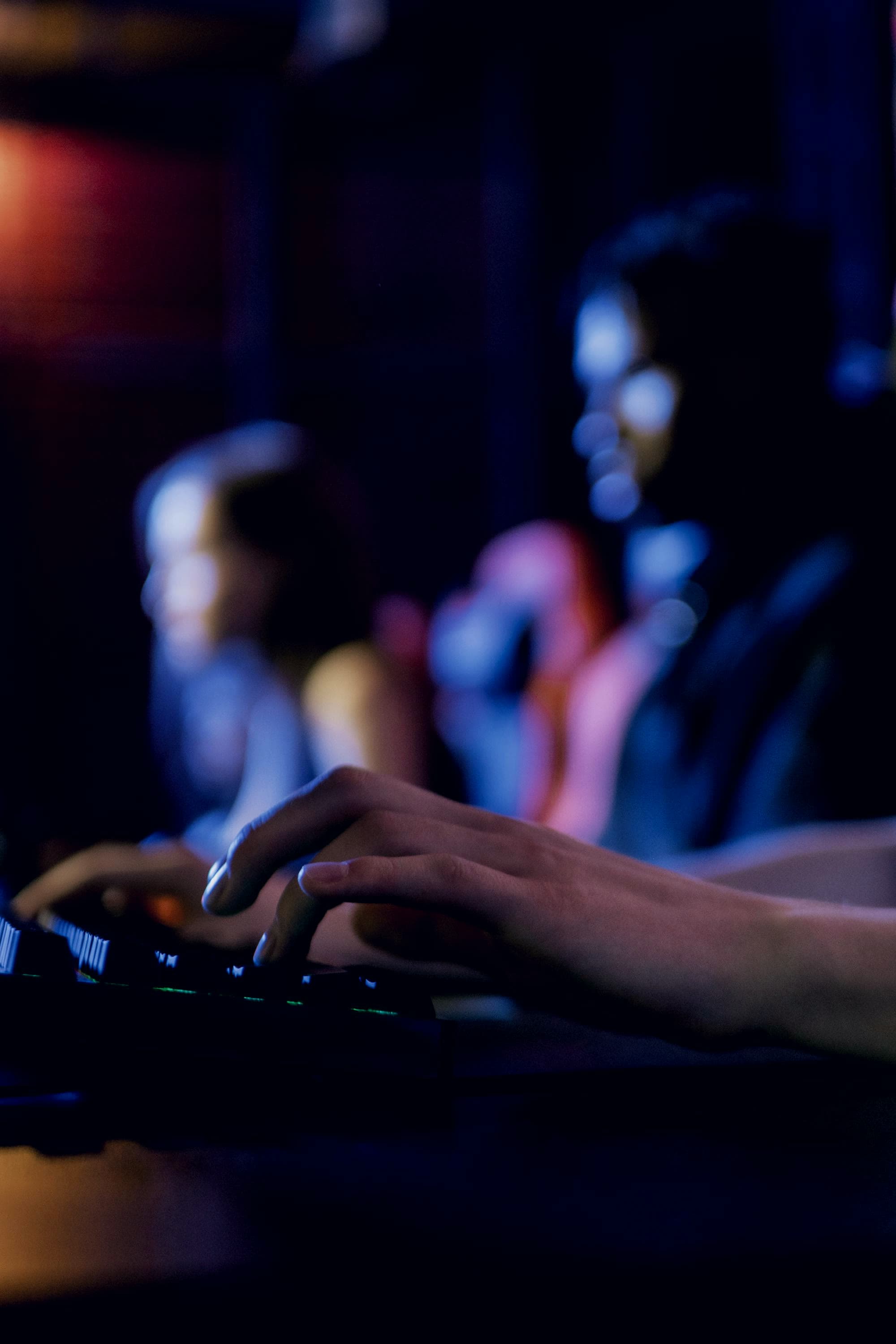 Hands at a backlit keyboard in the dark